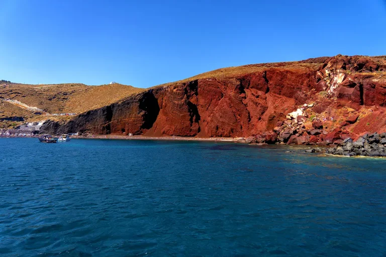 The crimson cliffs of Red Beach, Santorini, seen from the sea